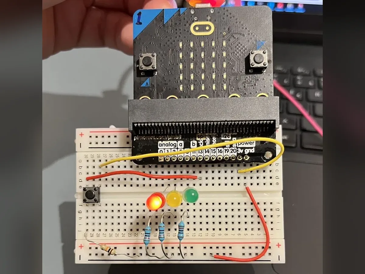 Red, yellow and green LEDs and a push button on a breadboard with a Micro:bit