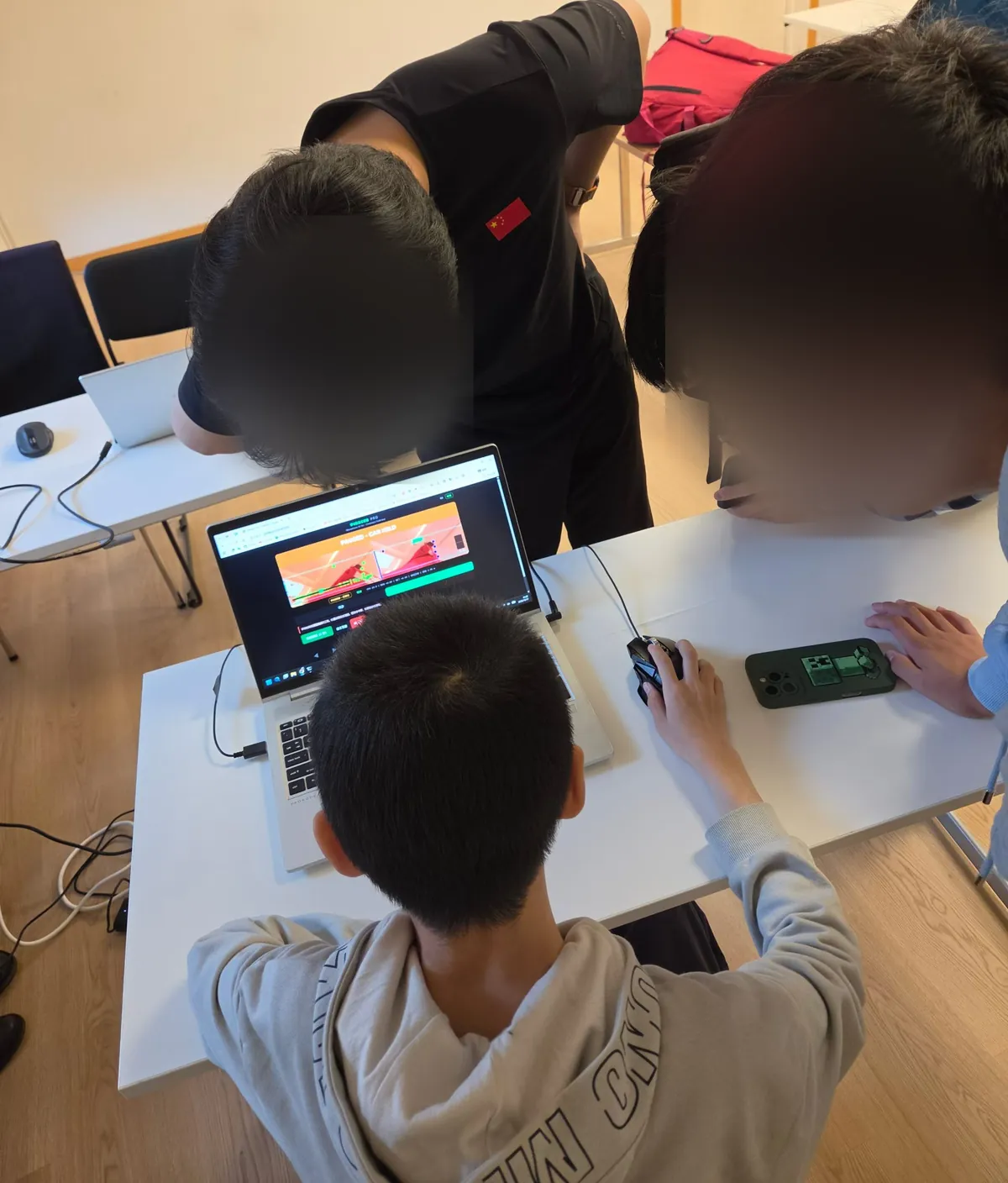 Three students looking at one laptop screen