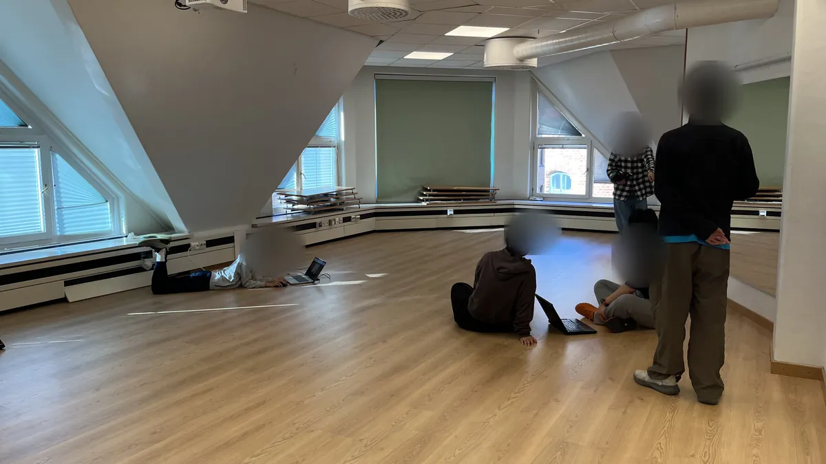 A large room where students test their cars on the floor